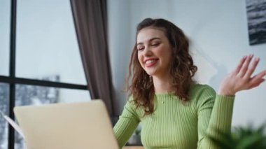 Çevrimiçi konuşan dizüstü bilgisayar okuyan olumlu bir kız. Neşeli özel ders videosu evde uzaktan çalışan bir bilgisayarı arıyor. Uzak görüşmede mutlu kadın girişimci planlama stratejisi