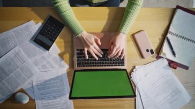 Üst görünüm elleri kurumsal işyerindeki klavyeye yeşil ekran bilgisayar yazma metni yazıyor. Tanımlanamayan bir ofis çalışanı internette geziniyor. Bilgisayarının yakın çekimini yapıyor. Bilinmeyen yazar çalışıyor