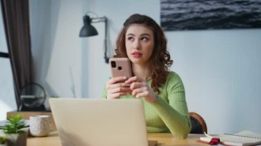 Ofisteki kız cep telefonunu kapatıyor. Gülen bir kadın uzak bir iş yerinde sosyal medyaya mesaj atıyor. Mutlu iş kadını, kapalı mekanda akıllı telefon çalmaktan zevk alır. Dijital yaşam tarzı kavramı 