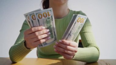 Kadın, 100 dolar nakit parayı yakın çekim olarak hesaplıyor. Bilinmeyen işçi satın almak için para tasarruflarını sayıyor. İş için para alan tanınmayan bir çalışan. Finansal zenginlik