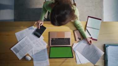 Üst düzey muhasebeci şirket işyerindeki yeşil ekran bilgisayarda çalışıyor. Tanımlanamayan ofis çalışanı, bütçe hesaplaması hazırlama raporunu hazırlıyor. Bilgisayarı kapatıyor. Bilinmeyen kadın belgelere bakıyor