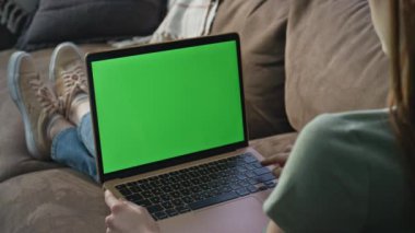 İnternette Chroma Key dizüstü bilgisayarında sörf yapan bir bayan daire kanepesinde dinleniyor. Evdeki yeşil ekran bilgisayarda çalışan tanınmamış bir kadın serbest yazar. Kanepede uzaktan kumandayla çalışan kız öğrenci.