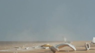 Bozuk paralarla parçalanmış kumbaralar tasarruflardaki finansal çöküşü sembolize ediyor. Erkek eli çekiçle kumbarayı kırıyor. Yatırım kaybı ve ekonomik kriz. Parçalanmış para kutusu parçaları