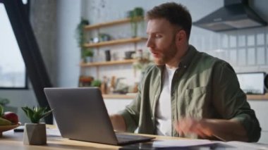 Memnuniyetsiz yönetici elinde kağıtlarla ev mutfağını kapatıyor. Gergin iş adamı online konferansta iş belgelerinden şikayet ediyor. Endişeli girişimci web sohbeti ile tartışıyor.