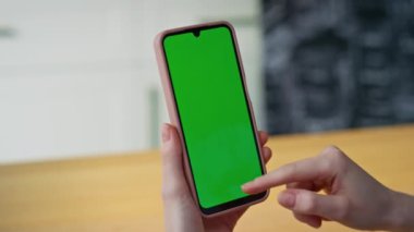 Kız parmakları daire kapanışında akıllı telefon çevrimiçi arama uygulamasını kaydırıyor. Kimliği belirsiz kadın yeşil ekran cep telefonuna dokunuyor. Kadın elleri kroma tuşlu cep telefonu mesajı okuyor.
