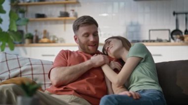 Evli çift kanepede sarılıp ev ortamının keyfini çıkarıyorlar. Sevecen erkek ve kadın rahat oturma odasındaki kanepede dinleniyorlar. Memlekette sevgi ve mutlulukla kaynaşan neşeli bir çift..