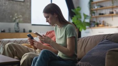 Kanepe oturma odasında yan yana oturan, cep telefonu arayan ciddi bir çift. Endişeli kadın akıllı telefondan erkeğe rahatsız edici mesajlar gösteriyor. Gergin genç eşler evdeki kanepede kötü haberler alıyorlar..