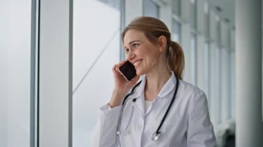 Gülümseyen terapist, sağlık kliniğindeki akıllı telefonu arıyor. Kapanış doktoru hastaya danışıp test sonuçlarını tartışıyor. Steteskoplu neşeli mutlu kadın hastane koridorunda dostça sohbet ediyor.