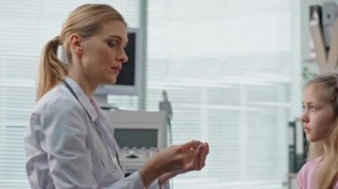 Çocuk doktoru hasta kızı yakından muayene ediyor. Ailesinin sağlık kliniğini ziyaret etmesinden endişeleniyor. Uzman doktor, vücut ısısı danışmanı çocuk. Ateşi olan genç bir hasta..