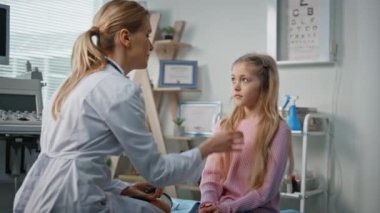 Modern tıp bürosunda genç bir kıza danışmanlık yapan bir doktor. Gülümseyen çocuk doktoru klinik koğuşunda hasta konuşuyor. Muayene odasında steteskopu olan sağlık görevlisini dinleyen sarışın çocuk. Sağlık kontrolü