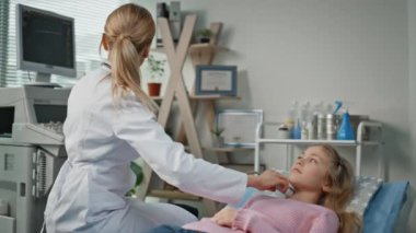 Ultrason doktoru pediatri kliniğindeki hastayı kontrol ediyor. Hastane koğuşunda konuşan kızı muayene eden gülümseyen bir kadın. Profesyonel analiz. Tıbbi sonografi ekipmanıyla bez taraması..