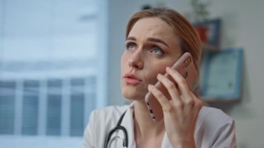 Tıp bürosunda cep telefonuyla konuşan ciddi bir doktor. Yorgun bir kadın hastasını arayıp tedavi sonuçları hakkında kötü haberler veriyor. Endişeli radyologlar hastanede sağlık danışmanlığı yapıyorlar.