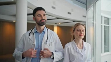 Tıbbi ekip hastane koridorunu kapatıyor. Beyaz üniformalı mutlu doktorlar sağlık merkezinde yürür. Steteskoplu gülümseyen sakallı doktor meslektaşına el sallıyor. Profesyonel klinik personeli