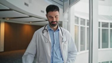 Hastanede gülümseyen pratisyen doktor panosuna benziyor. Mutlu işçi koridorda iş arkadaşını karşılıyor. Modern sağlık merkezindeki hasta bilgilerini analiz eden odaklanmış tıp uzmanı.