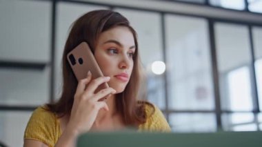İş yerindeki sinirli bayan cep telefonunu arıyor. Yakın plan. Gergin iş kadını akıllı telefon konuşmasını bitirdi. Ofis masasında dizüstü bilgisayarla oturuyor. Kötü haber duyan hoşnutsuz bir kadın endişeli bir sorun yaşıyor..