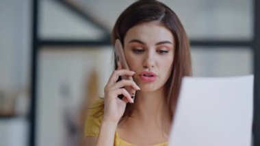 İş danışmanı, modern işyerindeki mali belgelere bakmak için cep telefonunu arıyor. Gülümseyen iş kadını cep telefonu sohbet ofisinde iş raporunu tartışıyor. Telefondan konuşan kendinden emin bir kadın.