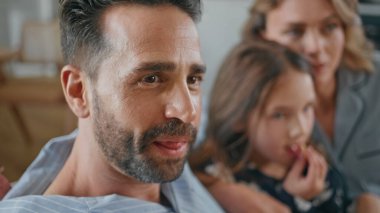 Baba 'nın ailesiyle birlikte sıcak bir dairede televizyon izlemesine şaşırdım. Mutlu ebeveynler ve kızları patlamış mısır yiyip kanepede film izliyorlar. Sakallı adam hafta sonları karısı ve çocuğuyla vakit geçiriyor.