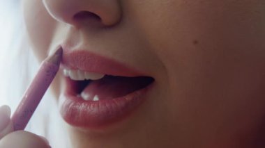 Sabah rutin çekimlerinde rujla boyanmış şehvetli dudaklar. Romantik randevu için makyajını dikkatlice yapan çekici bir kadın. Güzel bayan ağzı titizlikle pembe kozmetiklerle kaplanmış..