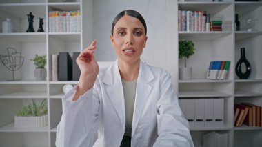 Doktor, pov videosundaki poliklinikte terapi reçetesi yazıyor. Kadın sağlık danışmanı tıbbi rehberlik sağlıyor. Sıhhiye modern klinikte online profesyonel danışmanlık yürütüyor.