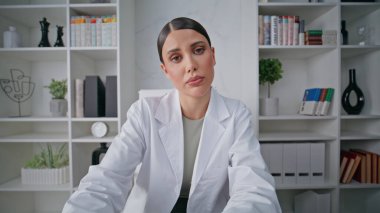 Klinikteki yakın çekim pov videosunda çevrimiçi konferans veren terapist. Portre kadın doktor hastanede online sağlık danışmanlığı yapıyor. Ciddi bir doktor uzaktan tedaviyi tartışıyor.