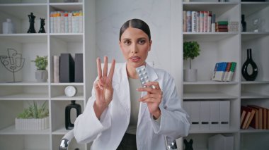 Çevrimiçi doktor klinikte ilaç dozajı talimatı veriyor. Kadın sağlık hizmeti sağlayıcısı ilaç yönergelerine pov videosu veriyor. Doktor tedavi detaylarını muayenehanede açıklıyor..