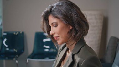 Modern ofis lobisinde dergi okuyan güzel bir kadın. Moda makalesine bakan şık bir iş kadını rahat koltukta oturuyor. Sakin bir bayan ziyaretçi koridorda dinleniyor iş görüşmesini bekliyor.