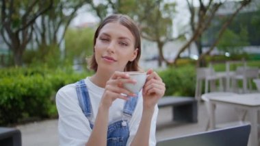 Kapalı kafede kahvesini yudumlayan kaygısız bir kız. Sokak yeşilliğinde kamerada gülümseyen güzel bir kadın elinde bardakta aromatik içecek tutuyor. Kafeterya terasında espresso bardağıyla poz veren rahat kadın..