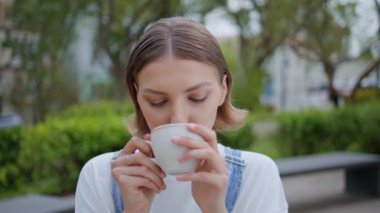 Park kafeteryasında espresso içen portre kadın. Dışarıdaki kafede kahve molası veren genç bir bayan. Rahat bayan hippi sokakta sıcak aromatik içecek yudumluyor..