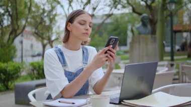 Sokak kafeteryasında dizüstü bilgisayarda çalışan ciddi bir kız. Parktaki kafede cep telefonu tutan zeki bir kadın. Genç bir kadın, dışarıdaki terasta bilgisayar başlığı takıyor.