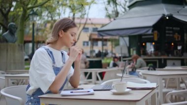 Rahat bir kadın cep telefonu mesajlarını kontrol ediyor. Sokağın karşısındaki kafede dizüstü bilgisayarla oturuyor. Genç kız öğrenci kafeterya masasında akıllı telefon tutarak internetten çalışıyor. Çekici iş kadını telefonuna göz atıyor.