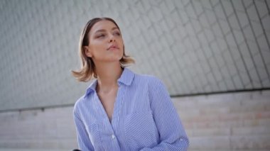 Zarif bir bayan modern mimarinin yakınındaki mesafeye bakarak toplantı bekliyor. Şehir binasının yakınında elinde akıllı telefon tutan dalgın bir kadın. Şık şehir manzarasında cep telefonu olan kendine güvenen bir esmer.