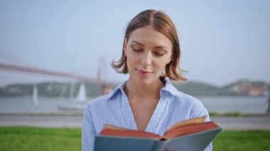 Doğada roman okuyan bir kadın nehir köprüsünün önünde yakın planda oturuyor. Park yeşili çimlerinde edebiyattan hoşlanan ciddi bir genç bayan. Sakin esmer öğrenci sakin yaz manzarasında bilgiye odaklanıyor..