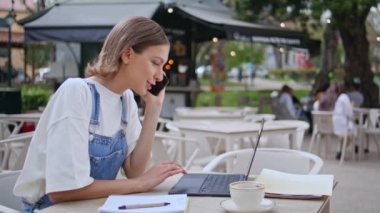 Sokak kafeteryasında iş görüşmeleri yapan bir kadını arıyorum. Cep telefonuyla konuşan gülümseyen kadın bilgisayarın dokunmatik pedini kaydırıyor. Cafe 'de cep telefonuyla iyi haberleri paylaşan mutlu serbest çalışan.