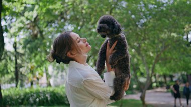 Güzel parkın kapanışında birbirine bağlanan sevimli bir köpek. Siyah kaniş tutan gülümseyen bayan dışarıda sevgi dolu anların tadını çıkarıyor. Yeşil doğada kürklü küçük bir evcil hayvanla duran neşeli kız. Hayvan sevgisi