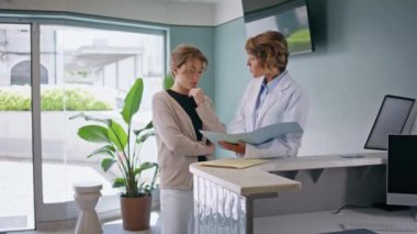 Doktor, ilgili bir kadın hastayla sağlık hizmetleri kliniğinde tedavi planını tartışıyor. Genç bir ziyaretçiye teşhisi açıklayan bir kadın. Hastane ofisinde tıbbi danışmanlık.