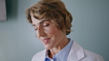 Gülümseyen pratisyen hekimler modern sağlık kliniğindeki kız hastalara danışmanlık yapıyor. Arkadaş canlısı orta yaşlı kadın doktor tedavi planını açıklıyor. Pozitif doktor hastane ziyaretçisiyle konuşuyor.