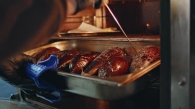 Restoran çalışanı profesyonel fırında patlıcan sıcaklığını kontrol ediyor. Siyah eldivenli bilinmeyen bir aşçı yemek için lezzetli patatesler pişiriyor. Kafeterya aşçısı mutfakta lezzetli sağlıklı yemekler hazırlıyor.