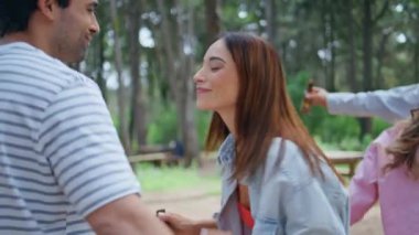 Orman pikniğinde dans eden gençler yaz tatilinde birlikte eğleniyorlar. Mutlu grup arkadaşları açık havada dinlenen müzik ritminin keyfini çıkarırlar. Gülümseyen arkadaşlar yeşil parkta cesetleri taşıyorlar.