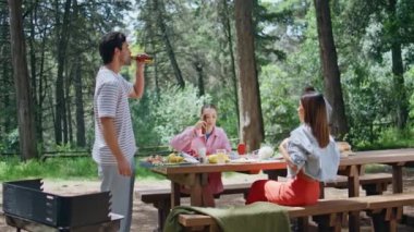 Kaygısız arkadaşlar güzel ormanda piknik yapıyorlar. Gülümseyen insanlar BBC partisine bisikletle geldiler. Mutlu grup gençleri bira içip doğada yemek yiyorlar. Dostça buluşmanın tadını çıkarıyorlar..