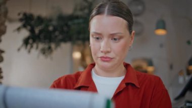 Kafeterya masasında oturmuş defter okuyan odaklanmış bir kadın. Profesyonel çalışma alanındaki raporlara odaklanmış iş kadını. Restoranda evrakları inceleyen düşünceli bir kadının portresi..