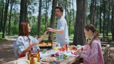 Kaygısız arkadaşlar güneşli ormanda bbq partisi veriyorlar. Rahat kadınlar masada taze sebze keserken yakışıklı adam yemek hazırlıyor. Mutlu gençler hafta sonunun tadını çıkarıyorlar..