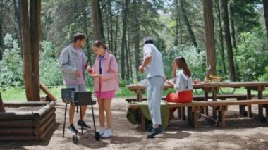 Grup arkadaşları ormanda piknikte yemek pişiriyor. Gençler hafta sonu Sunny Park 'ta toplanıyorlar. Mutlu gençler kömürde lezzetli yemekler pişiriyor. Dışarıda barbekü partisinin tadını çıkarıyorlar.