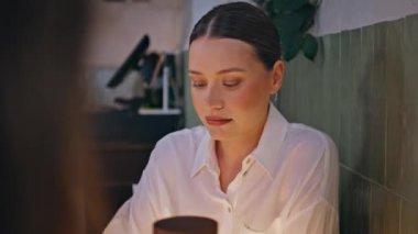 Kaygısız hafta sonu akşamında arkadaşlarıyla şarap içen bir kadın. Sakin, güzel bayan Merlot yudumluyor modern restoranda bilinmeyen bayanları dinliyor. Zarif esmer, dostça bir toplantının keyfini çıkarıyor..