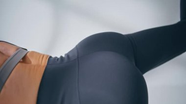 Closeup sportswoman butt raising leg training at home. Unknown sportswear woman doing exercise. Sport trainer girl showing asana. Lady burning calories practicing fitness. Pilates model stretching 