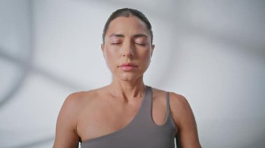 Stüdyoda meditasyon yapan barışçıl bir bayan. Serene kız, Asya 'da yoga eğitimi alıyor. Sabahları derin nefes alıyor. Gözleri kapalı sakin bir kadın sessizlikte farkındalık yapar. Zen yaşam tarzı konsepti 