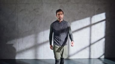 Spor adamı takibi çatı katındaki yakın çekimde sonuçlandı. Boş spor salonunda akıllı saati kullanan bir sporcu. Tatmin olmuş sporcu idmandan sonra akıllı görünüyor. Spor eğitmeni Grey Wall Stüdyolarında sonuçları kontrol ediyor. 