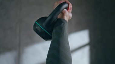 Vücut geliştirici el kaldırma tenceresi boş stüdyoda egzersiz yapıyor. Meçhul erkek, idman sırasında metal aletlerle kas egzersizi yapıyor. Spor yapan adam ağırlık kaldırıyor.