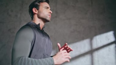 Spor salonundaki adam boş dairede dizini kaldırıyor. Kaslı esmer sporcu, spor salonunda antrenman yapmaya hazırlanıyor. Çekici sporcu adam evde egzersiz yaparken tek başına zıplıyor. Spor konsepti