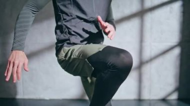 Boksör, spor salonunda bacaklarını ısıtıyor. Tanımlanamayan fitness elemanı içeri atlayan ayakları esnetiyor. Bilinmeyen erkek sporcu sıkı çalışma üzerinde gerilme egzersizi yapıyor. Spor yaşam tarzı konsepti