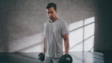 Spor yaparken dambılları kaldıran güçlü bir adam. Spor kulübünde halter egzersizi yapan ciddi bir sporcu. Bisepsi pompalayan genç bir adam. Sadece modern çatı katında erkek kaldırıcı eğitimi. 